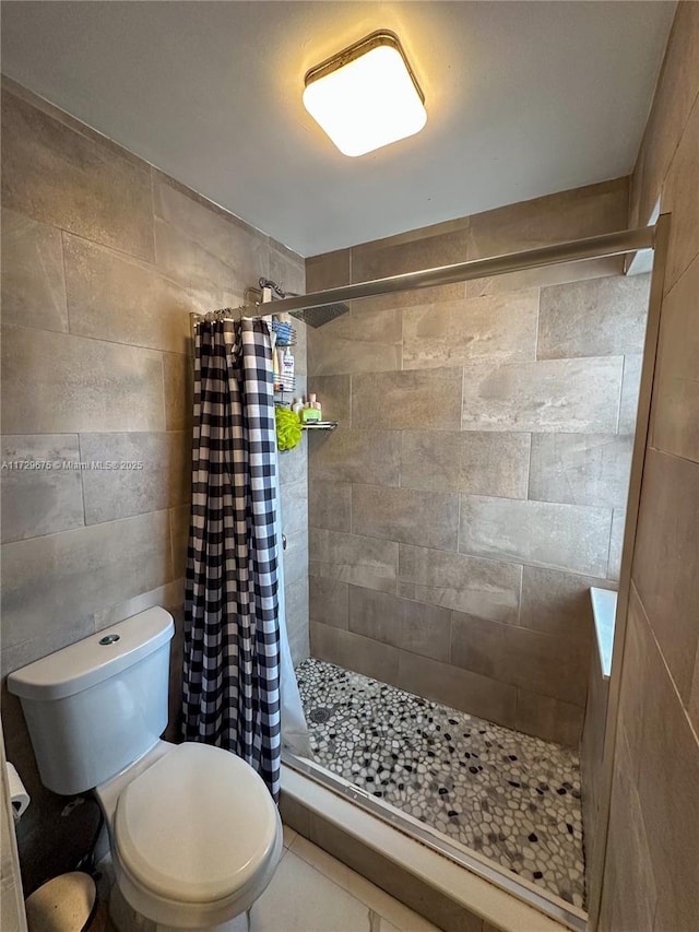 bathroom featuring a shower with curtain, toilet, and tile patterned floors