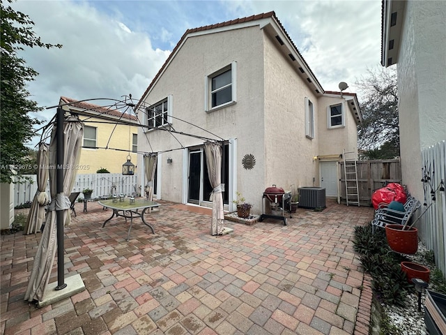 rear view of property with a patio area and central AC