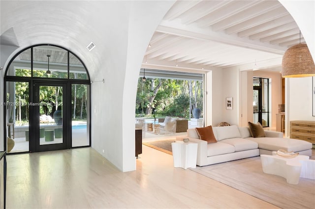 unfurnished living room with hardwood / wood-style flooring and beamed ceiling