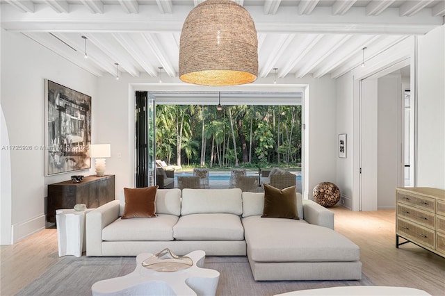 living room with beamed ceiling, a wealth of natural light, and light hardwood / wood-style flooring