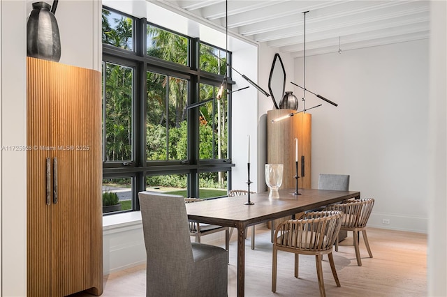 dining room featuring light wood-type flooring and beam ceiling