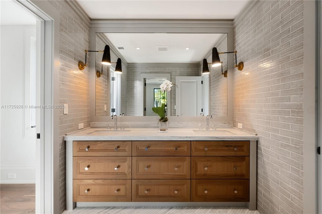 bathroom featuring vanity, brick wall, and hardwood / wood-style flooring