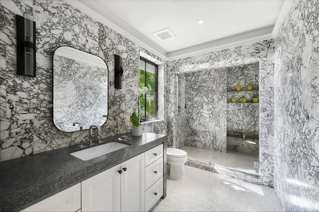 bathroom featuring tile patterned flooring, vanity, tile walls, toilet, and a tile shower