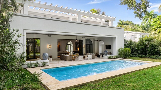 rear view of property featuring an outdoor hangout area, a pergola, an outdoor structure, and a patio