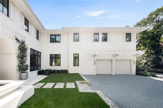 view of front of home with a garage and a front lawn