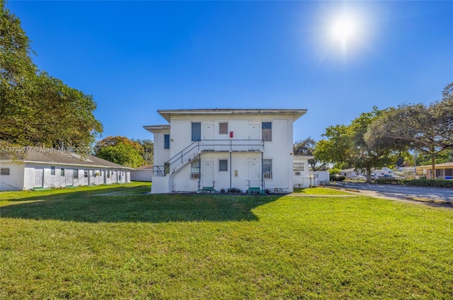 back of property featuring a lawn