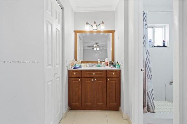 bathroom with tile patterned flooring, tiled shower, vanity, and ornamental molding