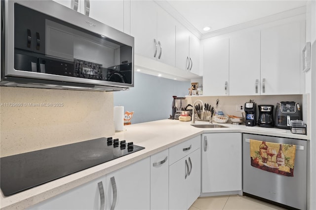 kitchen featuring stainless steel appliances, backsplash, white cabinets, and sink