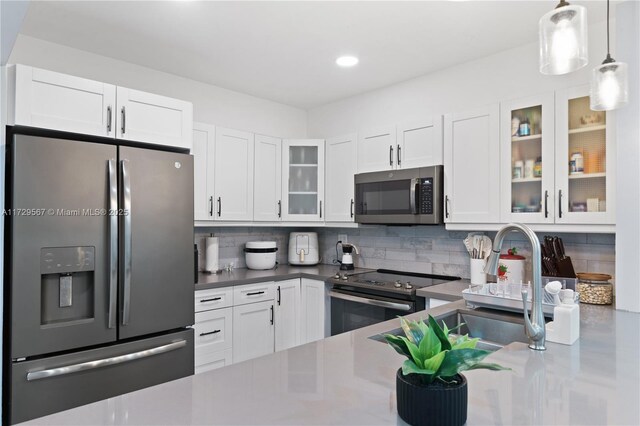 kitchen featuring backsplash, white cabinets, and stainless steel appliances