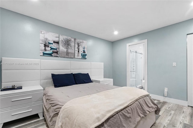 bedroom featuring ensuite bathroom and light wood-type flooring