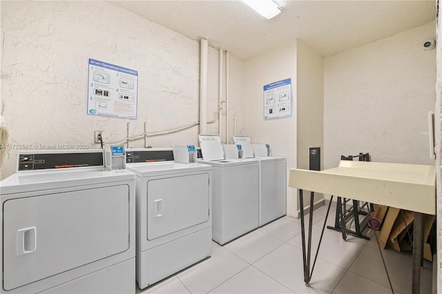 laundry area with washing machine and dryer and light tile patterned flooring