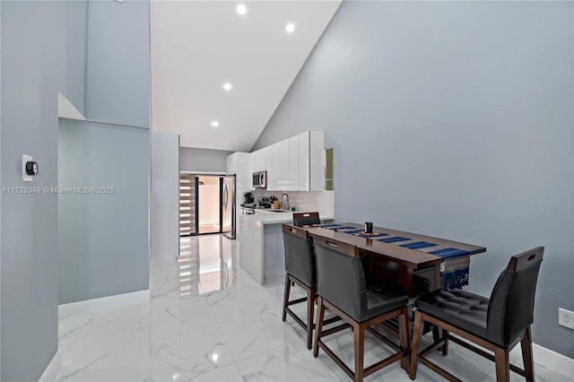 dining space with high vaulted ceiling and sink