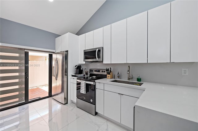 kitchen featuring sink, white cabinetry, lofted ceiling, and stainless steel appliances