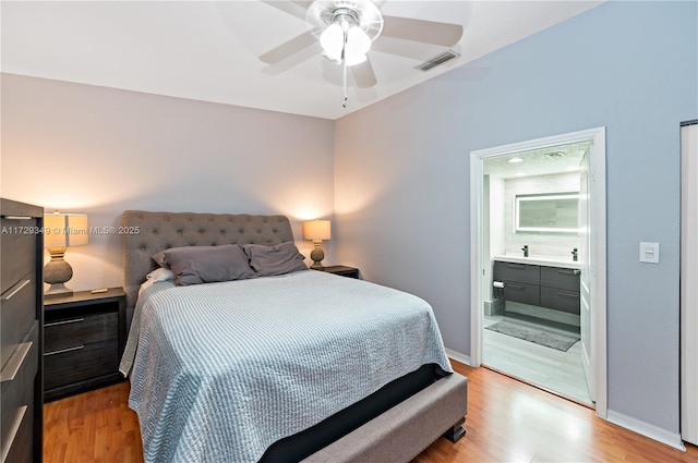 bedroom with ceiling fan, light hardwood / wood-style floors, and ensuite bath