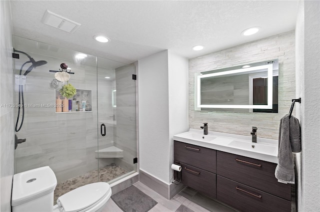 bathroom featuring toilet, a shower with door, tasteful backsplash, a textured ceiling, and vanity