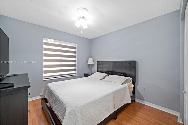 bedroom with ceiling fan and wood-type flooring