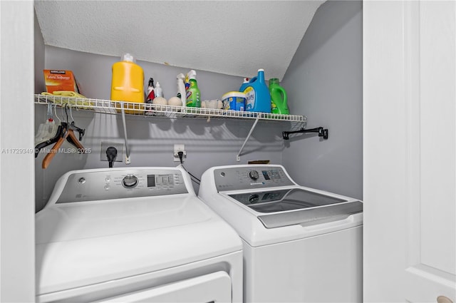 laundry area with a textured ceiling and washer and clothes dryer