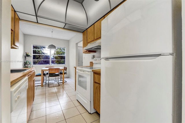 kitchen with decorative light fixtures, white appliances, and light tile patterned flooring