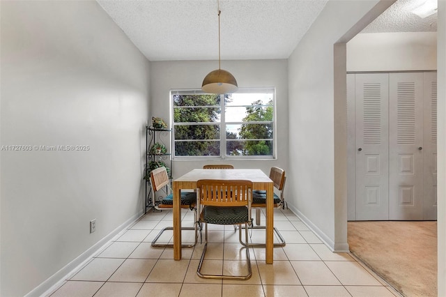 tiled dining room featuring a textured ceiling