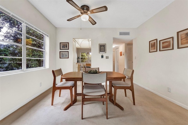 dining area with ceiling fan, light carpet, and a healthy amount of sunlight