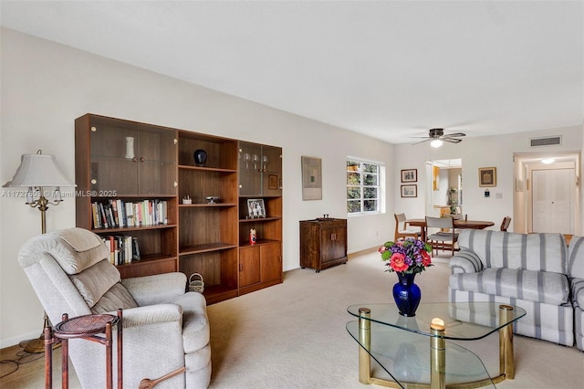 carpeted living room with ceiling fan