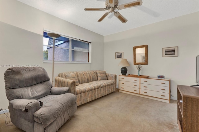 carpeted living room featuring ceiling fan and a textured ceiling