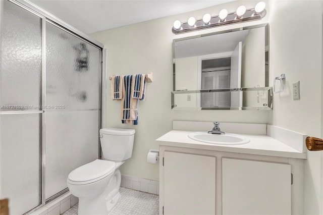 bathroom with a shower with shower door, tile patterned floors, vanity, and toilet