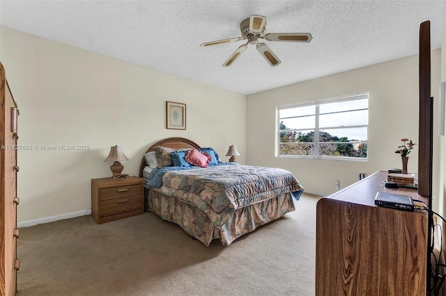 carpeted bedroom with ceiling fan and a textured ceiling