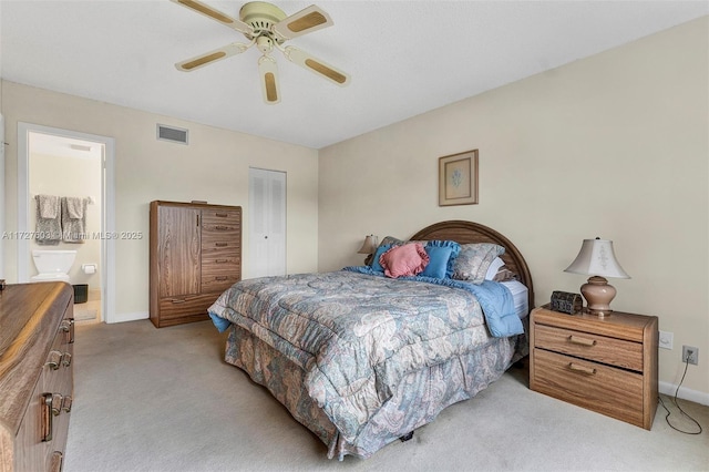 bedroom featuring a closet, ceiling fan, ensuite bathroom, and light carpet