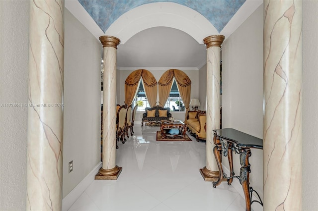 hall featuring decorative columns, crown molding, and tile patterned flooring