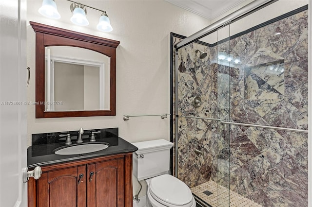 bathroom with toilet, crown molding, a shower with door, and vanity