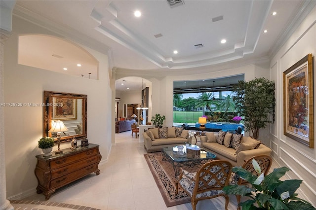 living room featuring crown molding, a tray ceiling, and light tile patterned floors