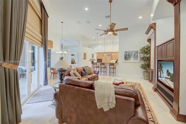 living room featuring light tile patterned flooring, ceiling fan with notable chandelier, a wealth of natural light, and crown molding