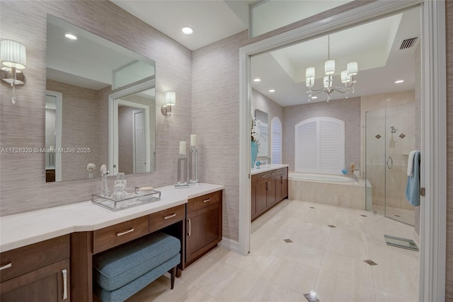 bathroom with tile patterned floors, an inviting chandelier, separate shower and tub, vanity, and a raised ceiling