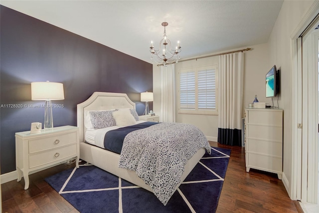 bedroom with dark hardwood / wood-style flooring and a notable chandelier