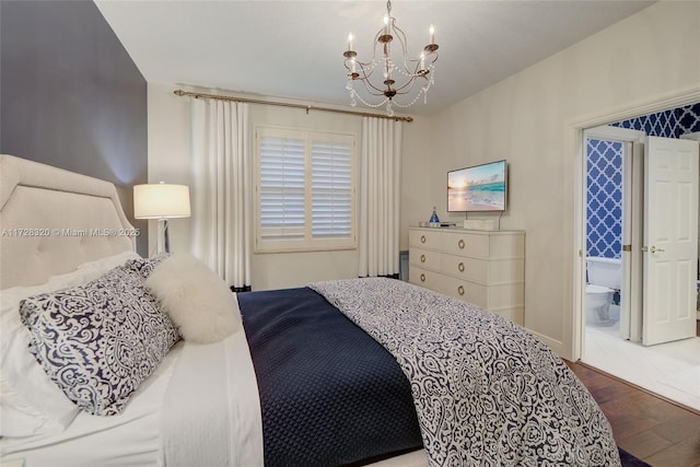 bedroom with ensuite bath, wood-type flooring, and a notable chandelier