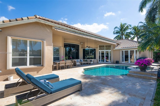 view of swimming pool with outdoor lounge area, a patio area, ceiling fan, and french doors