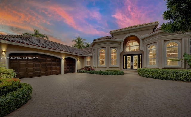 mediterranean / spanish-style house with a garage and french doors