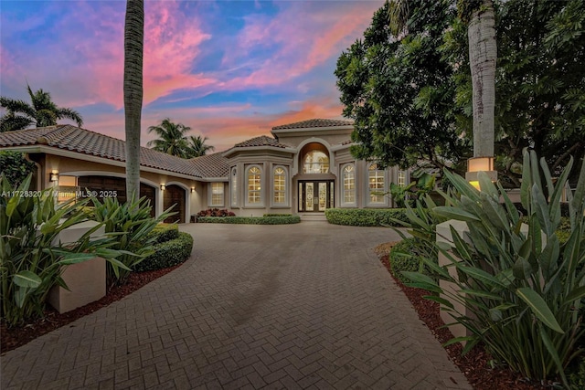 mediterranean / spanish home featuring a garage and french doors