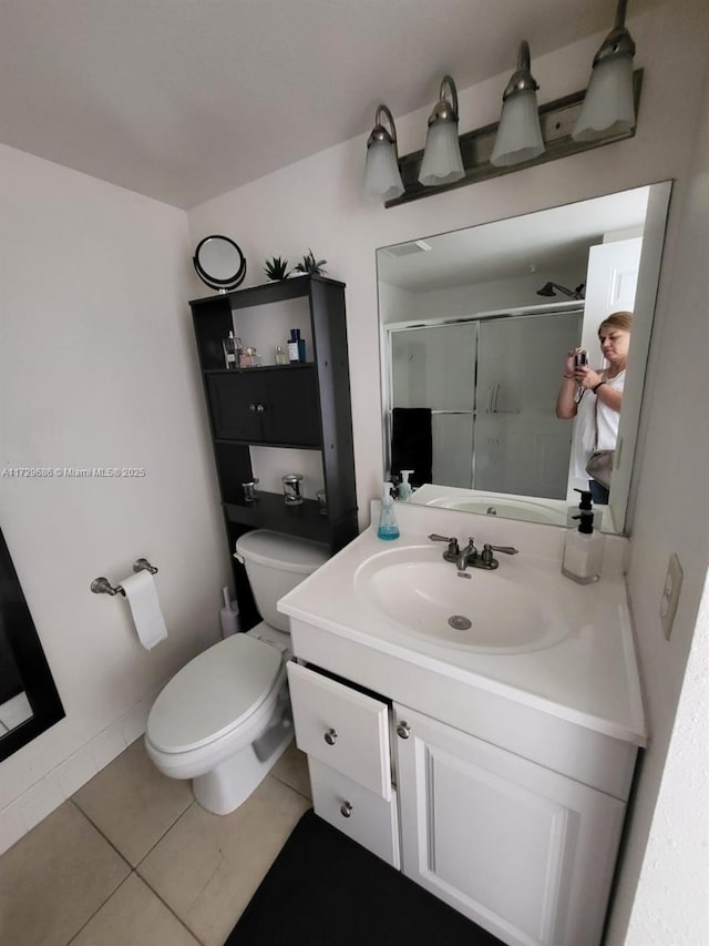 bathroom with vanity, toilet, tile patterned flooring, and an enclosed shower