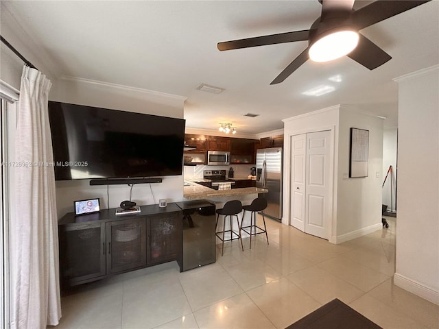 kitchen with stainless steel appliances, kitchen peninsula, ornamental molding, a breakfast bar, and light tile patterned floors