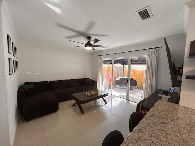 living room with ceiling fan, light tile patterned flooring, and ornamental molding