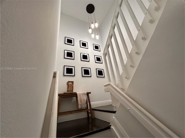 staircase featuring a notable chandelier and a towering ceiling