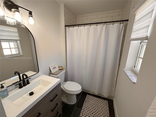 bathroom featuring toilet, a shower with shower curtain, tile patterned floors, and vanity