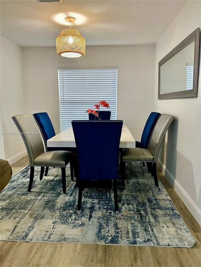 dining space with dark wood-type flooring and a textured ceiling