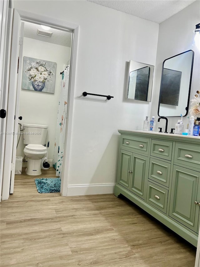 bathroom featuring vanity, hardwood / wood-style flooring, and a textured ceiling