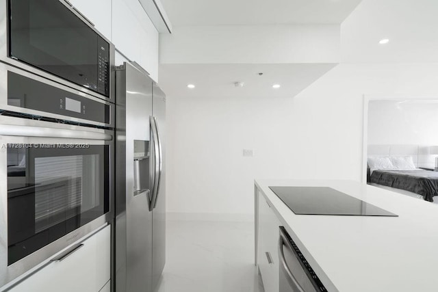 kitchen with white cabinetry and black appliances