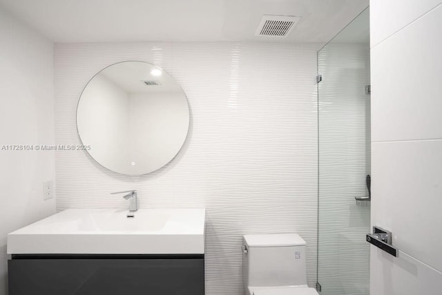 bathroom with tile walls, toilet, and vanity