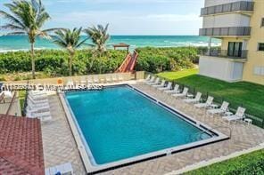 view of pool with a water view and a patio area