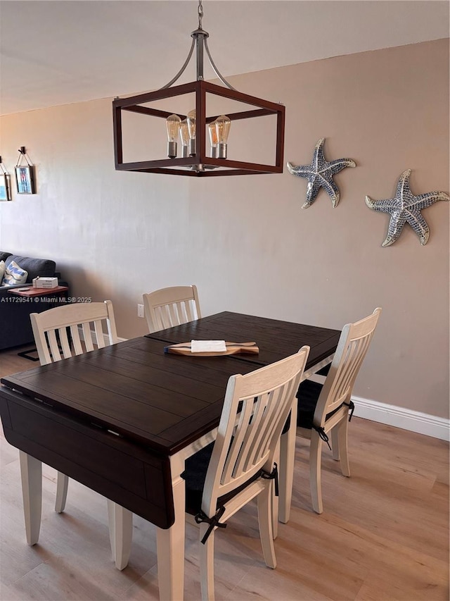 dining space with a chandelier and light hardwood / wood-style flooring